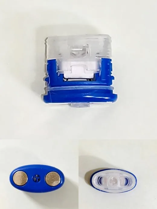 Three views of an empty pod with a blue base: the mouthpiece from above, the two contact pads from below, and the side profile